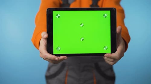 Close Up of Green Screen Tablet and Handyman Worker Isolated in Studio