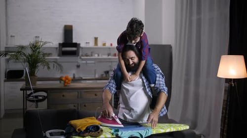 Father and Child Bonding While Ironing Clothes