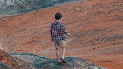Young Adult Walking on Barren Terrain