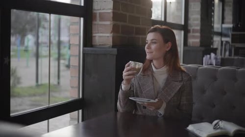 Smiling Woman Enjoys Coffee in Cozy Cafe