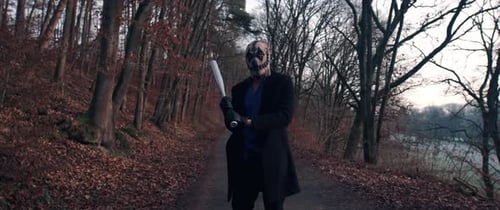 Masked Figure with Baseball Bat in Autumn Woods