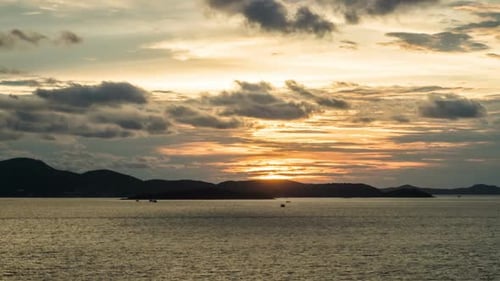 Golden Sunset Over Calm Ocean with Distant Islands