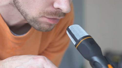 Man Eating Potato Chips Next to a Microphone