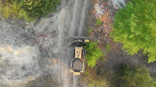 Top-Luftaufnahme von Bulldozer-Fahrten auf der Sandy Road auf der Baustelle