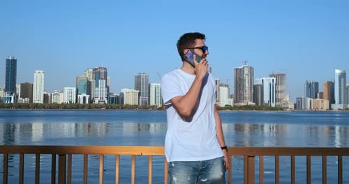 Smart Phone Man Calling on Mobile Phone at in City. Handsome Young Business Man Talking on