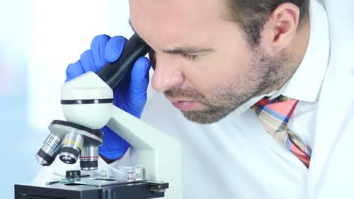 Scientist Uses Microscope for Research and Analysis