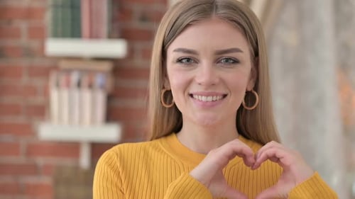 Woman Makes Heart Shape with Hands Smiling