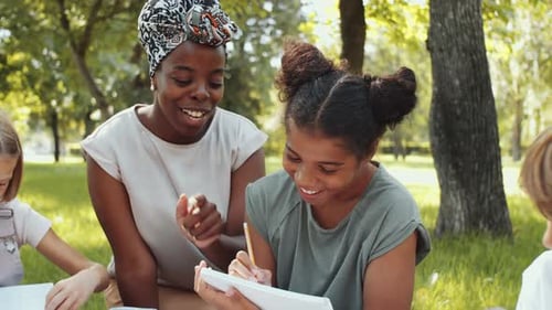 Afro-American Female Teacher and Schoolgirl Smiling at Camera in Park