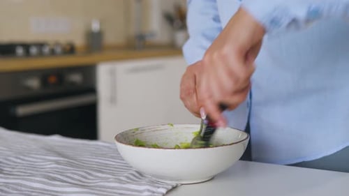 Mashing Avocado in a Bowl for Guacamole Preparation