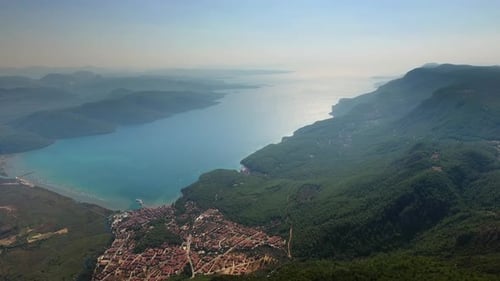 Eine kleine Stadt an einer bewaldeten Bucht und einer fruchtbaren Auenebene am Meer