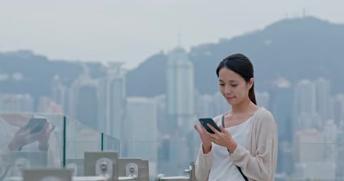 Woman look at mobile phone in Hong Kong city
