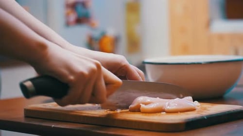 Hände schneiden frisches Fleisch, Fleisch auf einem Küchenbrett schneiden, rohes Fleisch schneiden