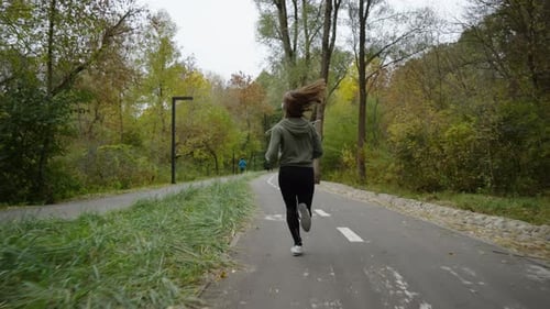 Fit Woman Jogging in Park in the Morning