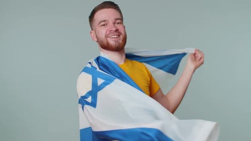 Man Smiles and Waves the Flag of Israel