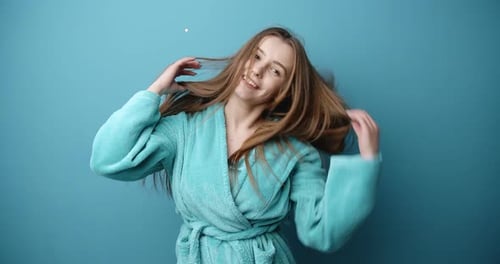Lovely Girl with Long Hair in Bathrobe Having Fun in Studio