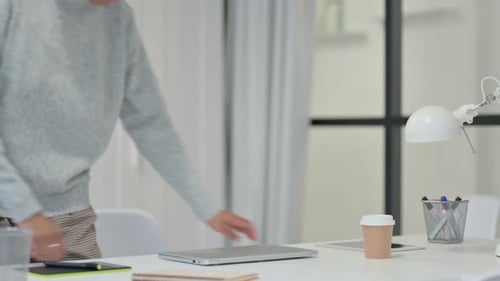 Woman Opens Laptop and Begins Working at Desk