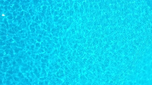 Blue Water in the Swimming Pool with Light Reflections