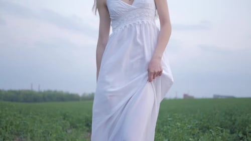 spring fashion portrait of a beautiful happy young woman in white dress with long brown hair walk th