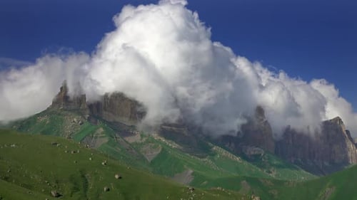 Mountains Partially Obscured By White Clouds Under Blue Sky
