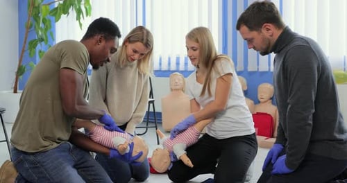 Adults Learning Infant CPR in Bright Classroom