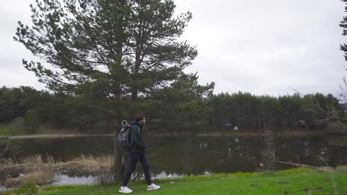 Young man walking by the lake. Hiking.