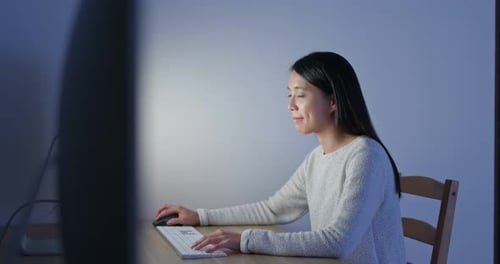 Woman Works on Desktop Computer at Home