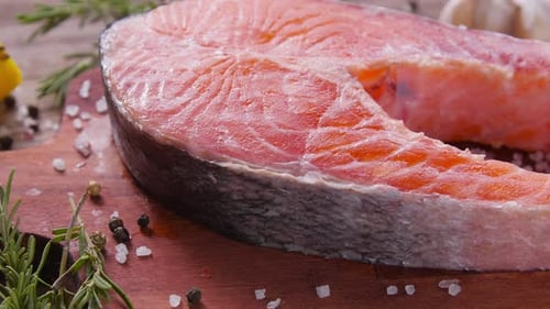 Rohes, frisches Lachssteak auf einem Schieferbrett und Gewürzen rundherum. Gesundes Lebensmittel-Konzept