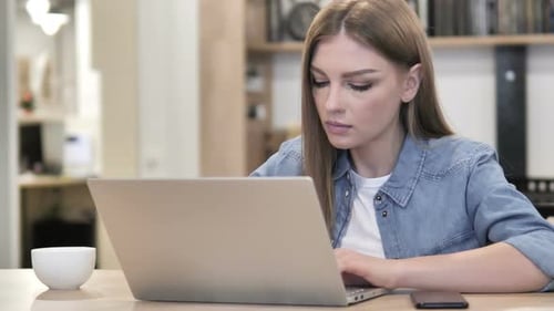 Young Adult Woman Works on Laptop Indoors
