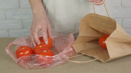 Woman Transfers Tomatoes from Plastic Bag to Paper