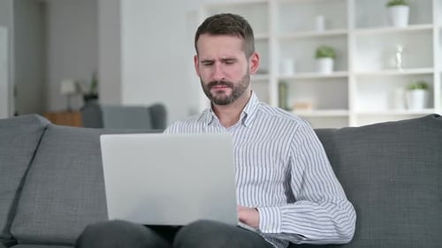 Man with Headache Working on Laptop at Home