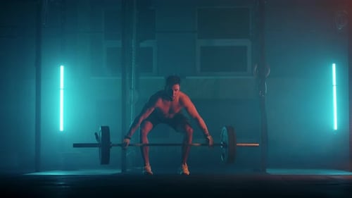 Athletic Shirtless Man Training Doing Power Strength and Endurance Exercises with Barbell