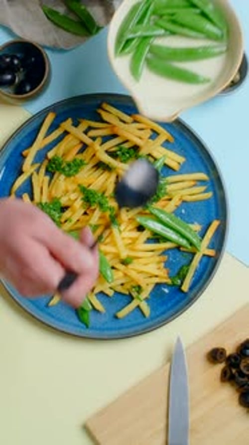 Preparing Fries with Peas and Olives