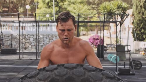 Athletic Man in Outdoor Gym Doing a Set of Deadlifts with Barbell