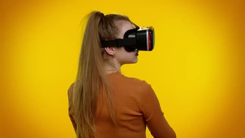 Woman Using Virtual Reality Headset on Yellow Background
