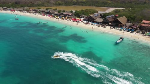 Tropical White Sand Beach Water Scooter at Speed in Beautiful Crystal Clean Blue Water Aerial View