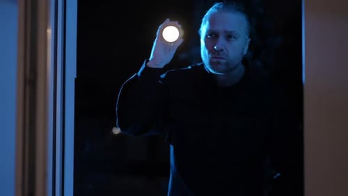 Man with Flashlight at Dark Doorway at Night