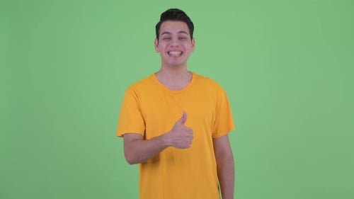 Young Adult Smiling Giving Thumbs Up on Green