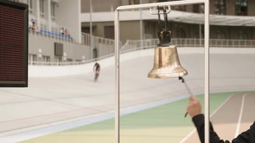 Cycling referee rings bell on velodrome during bike race competition