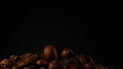 Zeitlupe fallender gerösteter Kaffeebohnen.