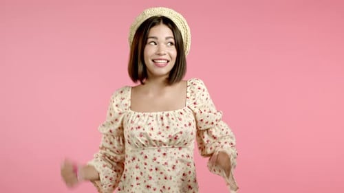 Beautiful Woman Dancing Energetically and Actively on Pink Studio Background. Cute Girl's Portrait