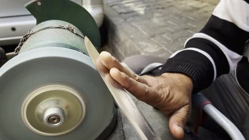 Man sharpening kitchen knife with machine