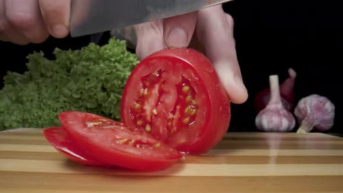 Slicing Fresh Red Tomato on Cutting Board