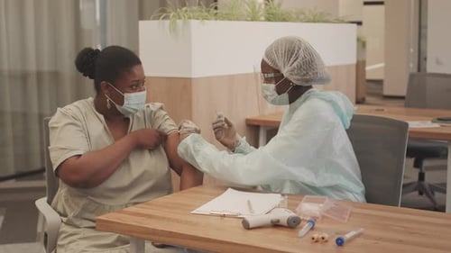 Healthcare Worker Gives Woman a Shot in Office