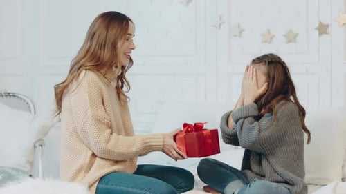 Woman Gives Birthday Gift to Happy Child