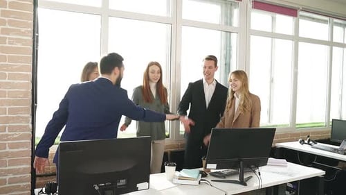 Colleagues Celebrate Successful Teamwork in Modern Office