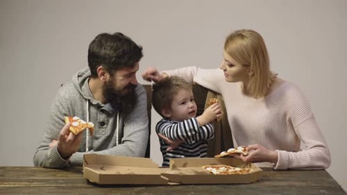 Family with Child Eating Pizza Together