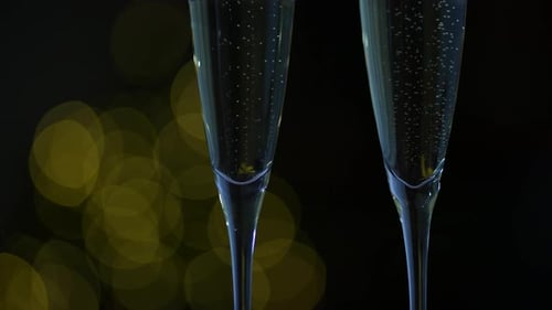 Close Up of Bubbling Champagne Flutes with Lights