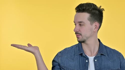 Young Man Presenting With Open Hand Gesture