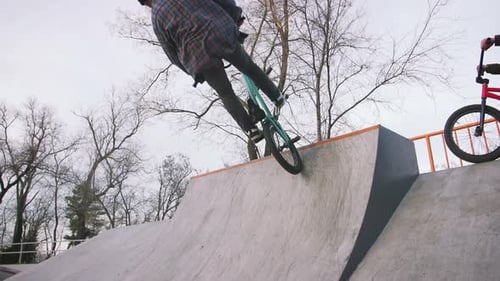 BMX Rider Doing Tricks in Street Plaza Bicycle Stunt Rider in Cocncrete Skatepark Super Slow Motion