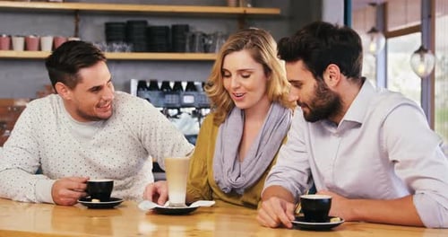 Three Young Adults Talking at a Cafe Counter